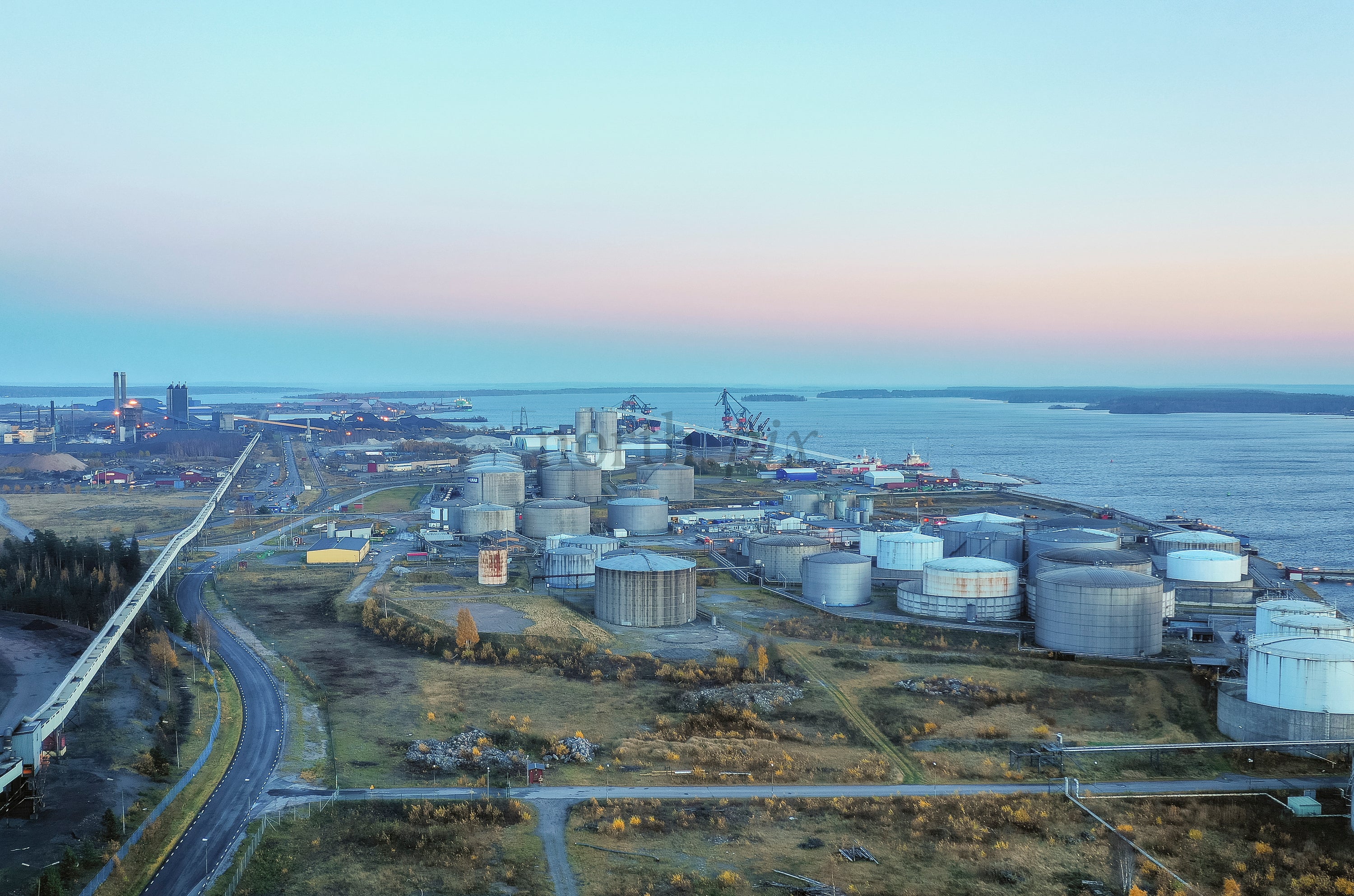 Aerial view of coastal storage tanks at dusk