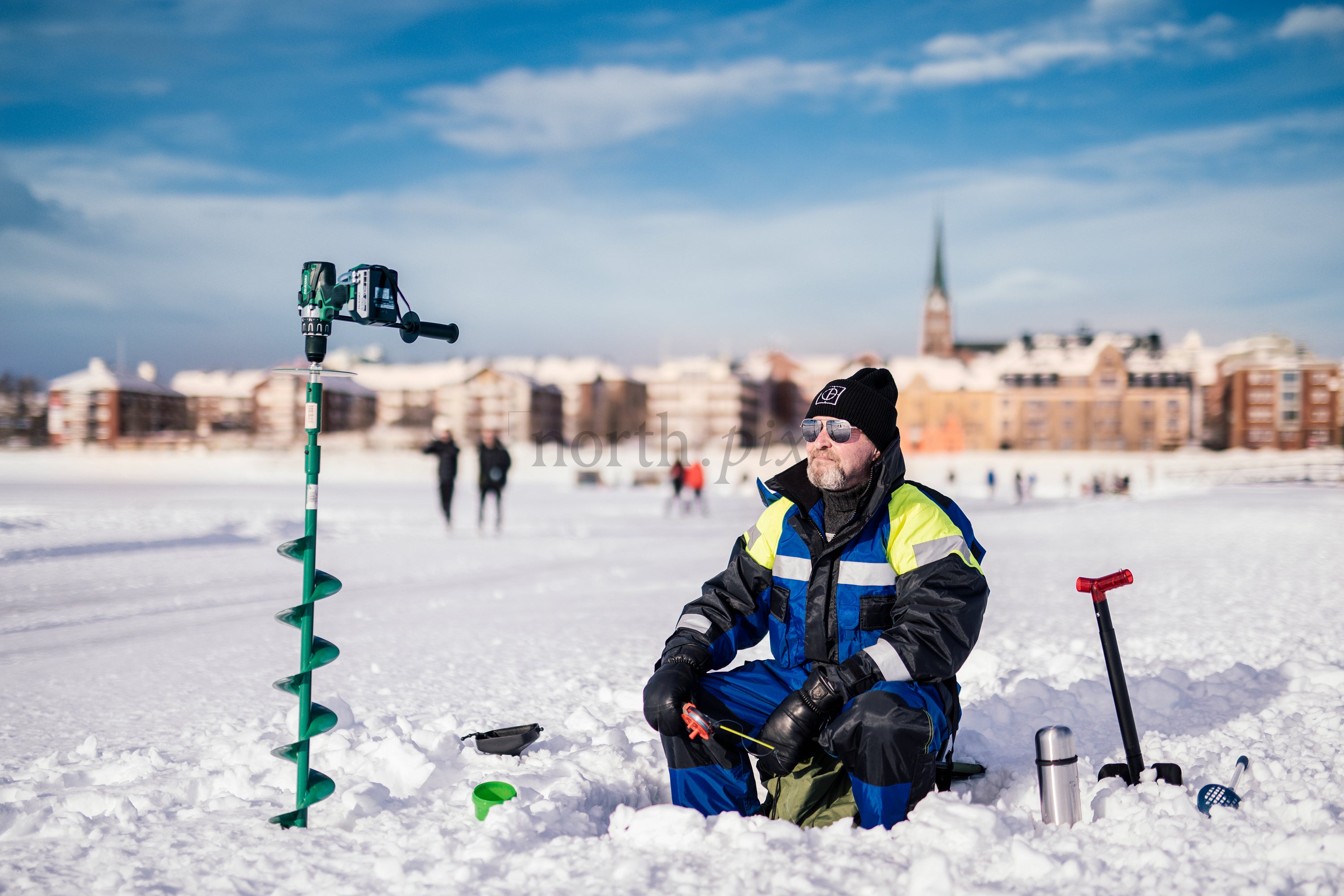 Man ice fishing on a frozen lake in winter
