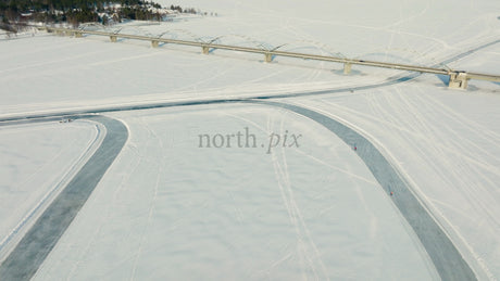 Aerial View of Frozen River and Bridge in Lulea, Sweden, Winter Landscape with People