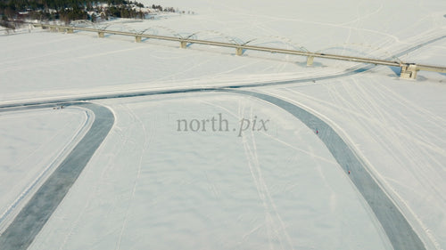 Flygfoto över frusen flod och bro i Luleå, Sverige, vinterlandskap med människor