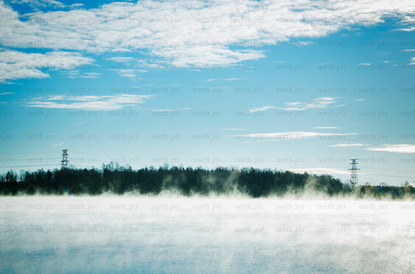 Lake with morning mist and power lines