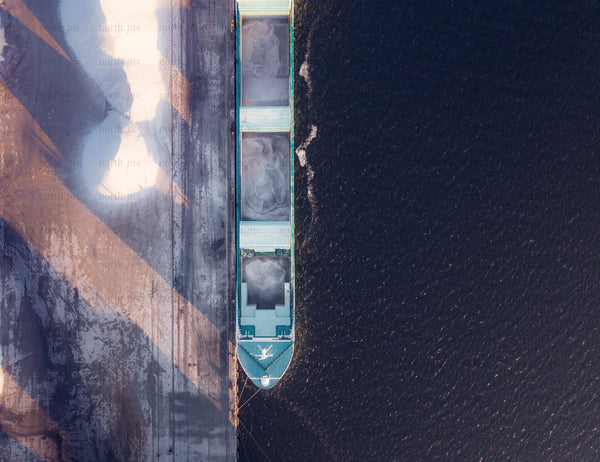 Aerial view of bulk carrier docked at quay at sunrise