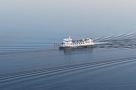 White Ferry Cruising Through Calm Blue Waters Near Luleå City Center On a Clear Day