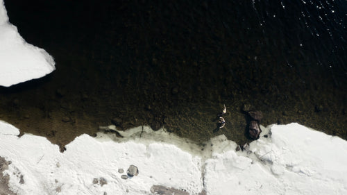 Vinterisbad i Luleå, Sverige: Flygfoto från drönaren på två personer i iskallt vatten