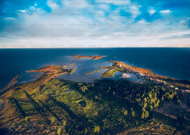 Drone view of coastal islands at sunset with forest and water