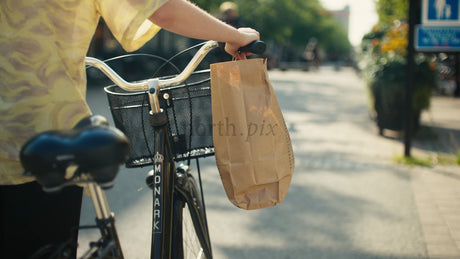 Woman Walks Her Bicycle on Sunny Lulea Street on a Summer Day