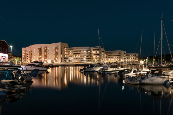 Night marina with moored boats and waterfront apartments