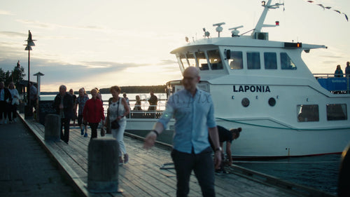 Passagerare som går iland från färjan vid solnedgången på Luleå pir i Sverige