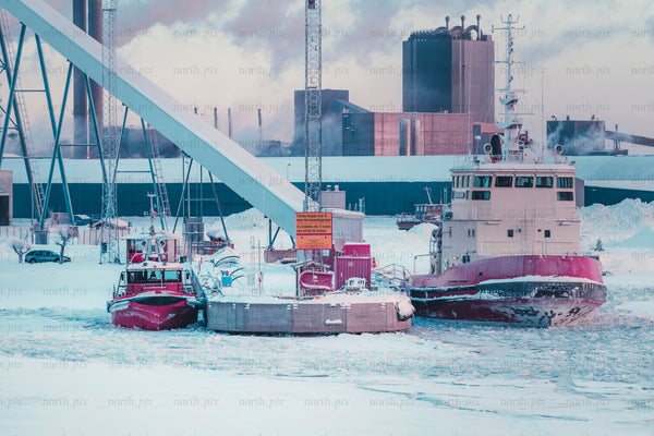 Tugboats at industrial harbor in winter