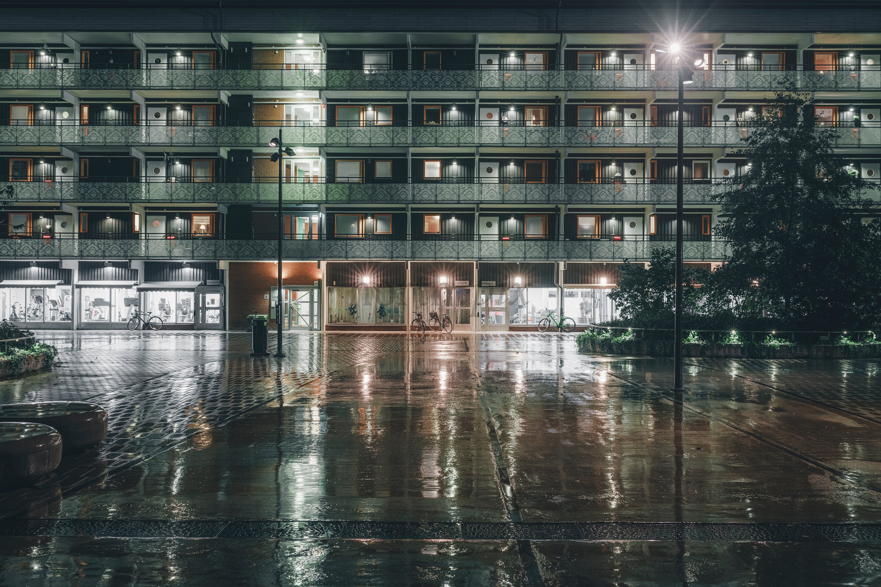 Night view of apartment building and wet plaza