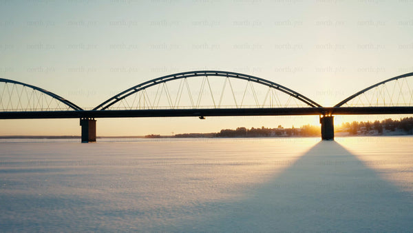 Winter sunset over frozen river and bridge in Luleå: Aerial drone footage