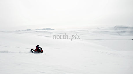 Snowmobiling Across a Snowy Landscape in Ritsem