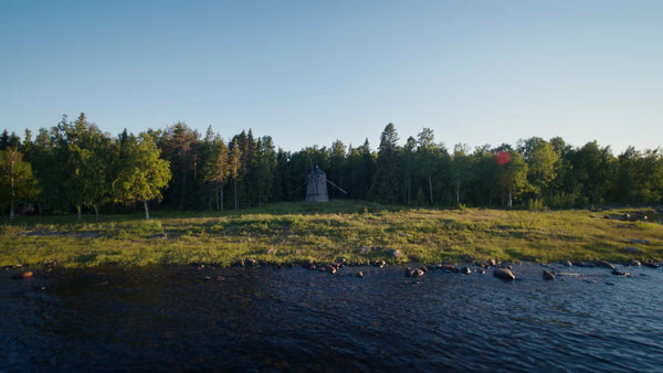 Summer Evening in Luleå Archipelago: Drone View of Windmill, Coastline, and Forest at Golden Hour