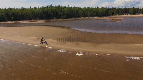 Fatbike rider in Sandön archipelago, Luleå: A summer day drone shot