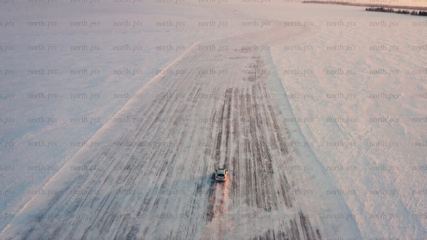 Driving car on frozen ice road in Luleå archipelago during winter sunset