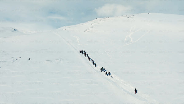 Group hiking up snowy mountain in Riksgränsen