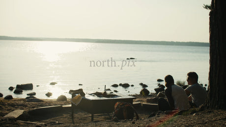 Romantic Camping Couple Enjoying a Scenic Sunset by the Lake in Lulea, Sweden