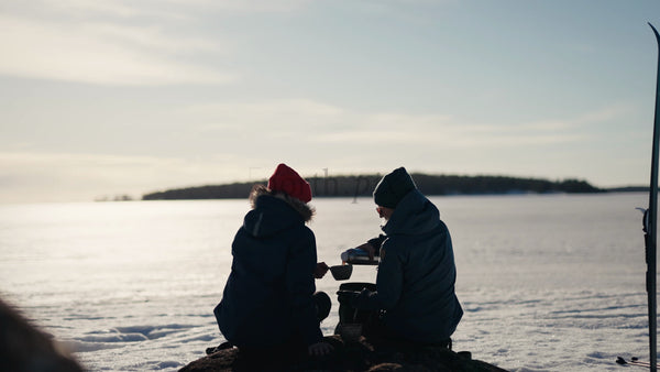 Winter Day in Luleå Archipelago: Two People Enjoy a Warm Drink by a Frozen Lake