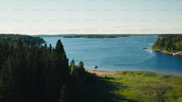 Summer in Luleå Archipelago: A Drone View of the Calm Bay, Pine Forest, and Boats