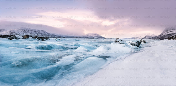 Stora sjöfallet - panoramic frozen lake and snow-covered mountains at sunrise
