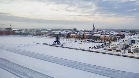 Winter in Luleå: Ice Skating on a Frozen Lake at Dusk - Aerial View of Cityscape