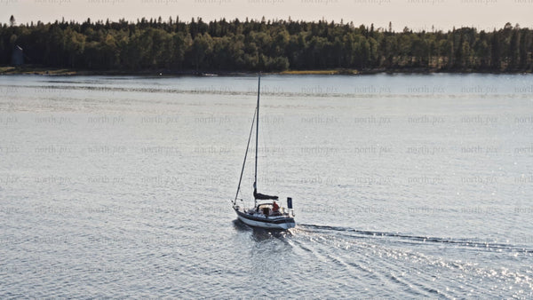 Sailing on Luleå river on sunny summer day, aerial drone footage