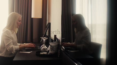 Businesswoman Working on Laptop in Modern Hotel Room