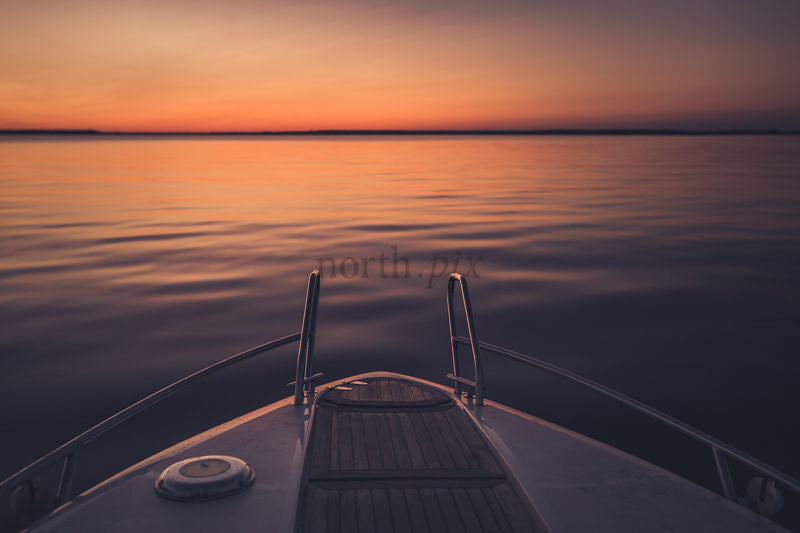 Boat bow at sunset over lake
