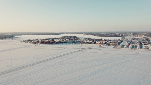 Flygfoto över Luleå stadsbild på vintern vid solnedgången på den frusna sjön