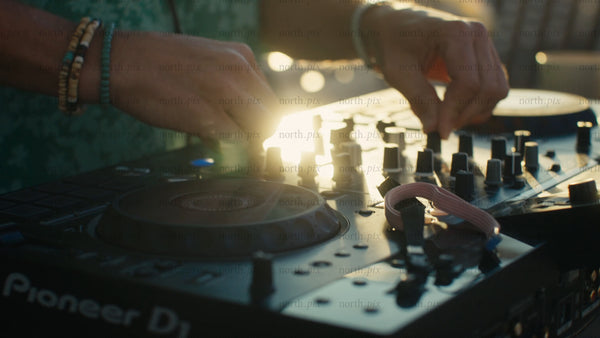 DJ mixing music at a summer sunset event