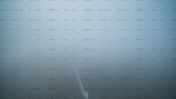 Wind turbine emerging from fog: Aerial view of renewable energy in Haraholmen