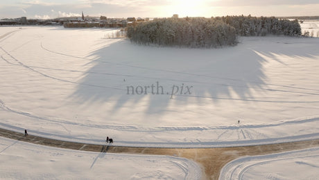 Winter Wonderland in Lulea: Aerial View of Snowy Landscape with People Strolling Along Path
