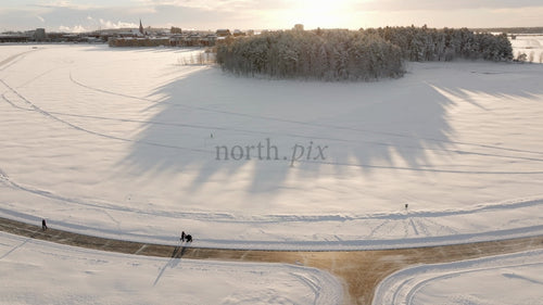 Vinterland i Luleå: Flygfoto över snöigt landskap med människor som promenerar längs stigen