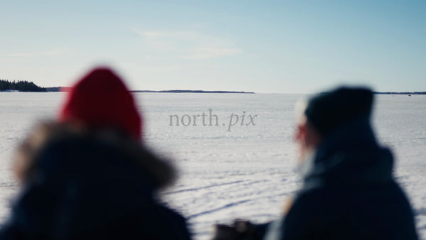 Winter in Luleå Archipelago: Two People on a Frozen Lake on a Bright Day