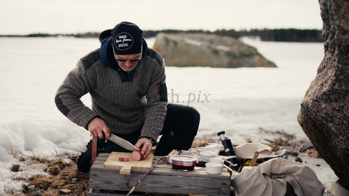 Vinterpicknick i Luleå skärgård: Man lagar mat vid en frusen sjö i Sverige