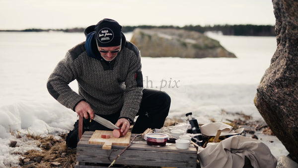 Winter Picnic in the Luleå Archipelago: Man Prepares Food by a Frozen Lake in Sweden