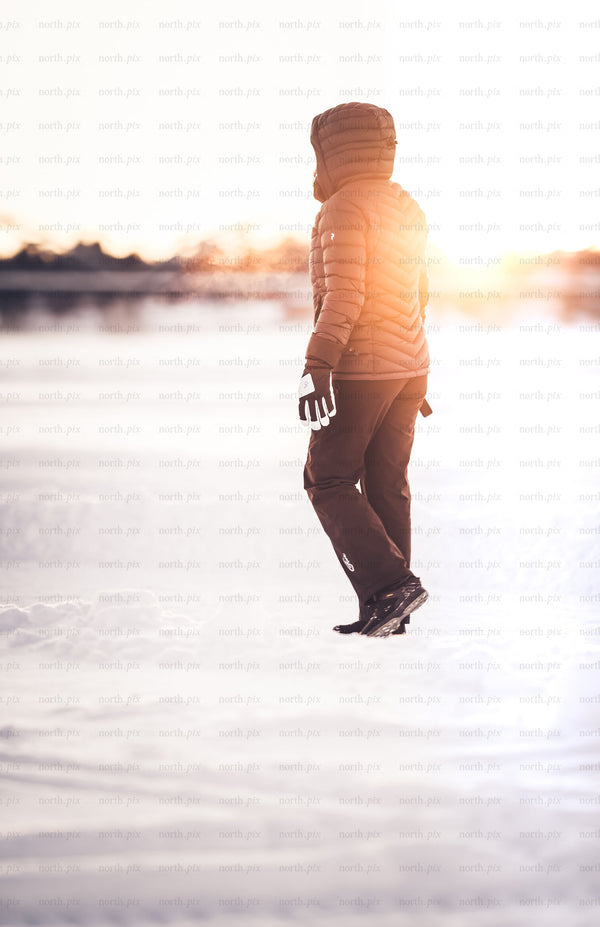 Person walking on snow at sunrise in winter