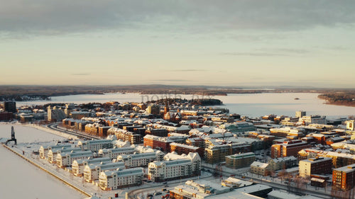 Flygfoto från drönare över snötäckta Luleå, Sverige, på vintern vid gyllene timmen