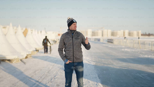 Man gives thumbs-up in wintery Luleå urban landscape