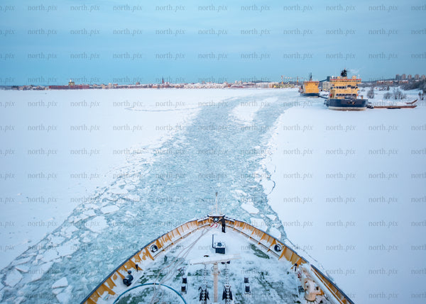 Icebreaker ship navigating frozen waters during winter after bright morning