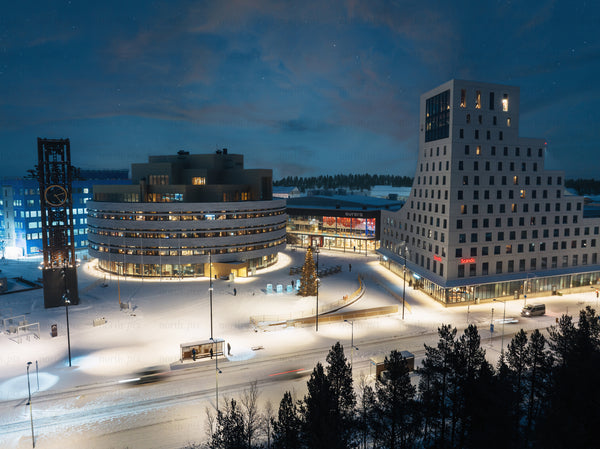 Night view of Kiruna modern center with snow, clock tower, and Christmas tree