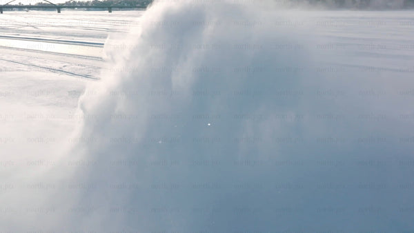 Tractor clearing snow on frozen lake in winter, Luleå - aerial drone footage