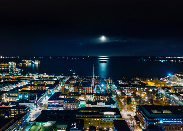 Nighttime aerial view of Luleå cityscape with moonlit bay