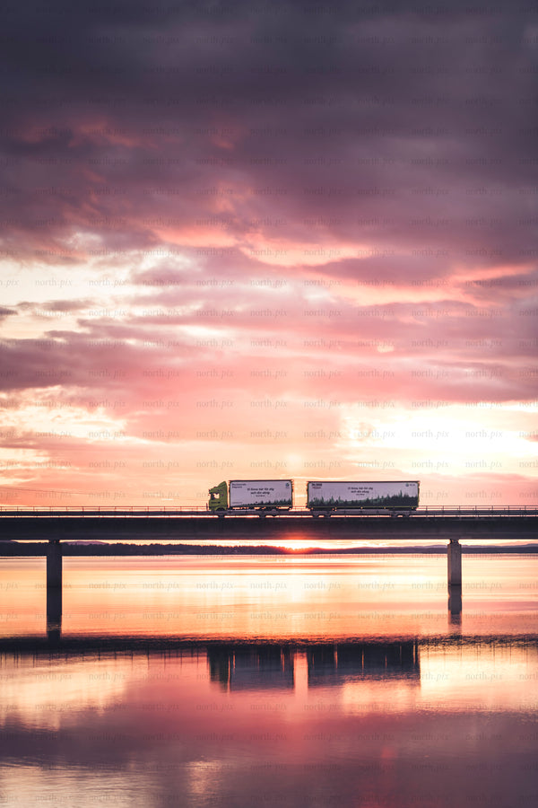 Long haul truck on bridge at sunrise