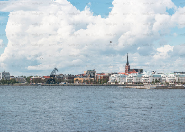 Waterfront city skyline with church spire and crane