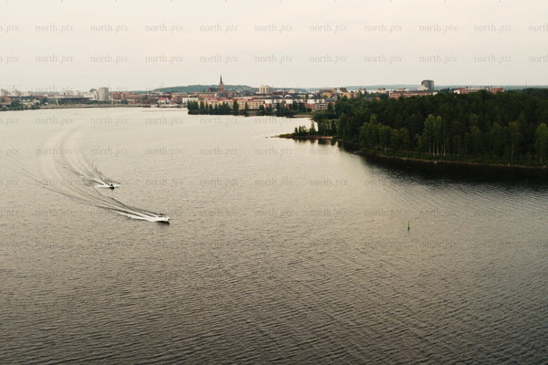 Aerial view of Luleå city center with boats on calm river and green island