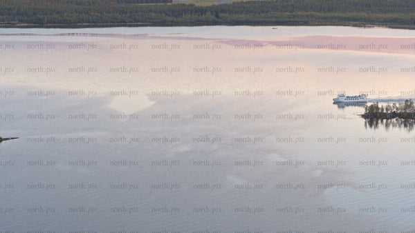 Luleå summer sunset: Ferry and boat on calm lake with scenic reflections