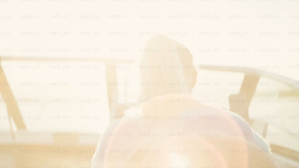 Woman steering boat in the Luleå archipelago. Summer sunshine, lens flare. Baltic Sea. POV