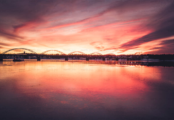 Arched bridge over river at sunset with reflection