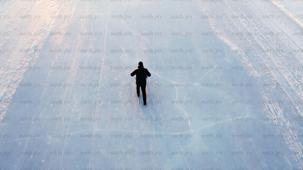 Man kicking on frozen lake in Luleå - winter landscape aerial drone view